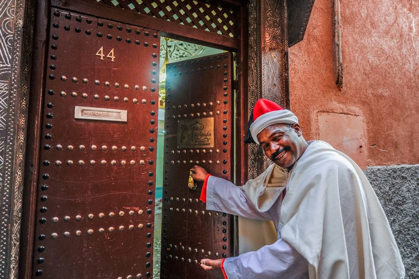 The host opens the wooden door number 44 of Riad Milouda